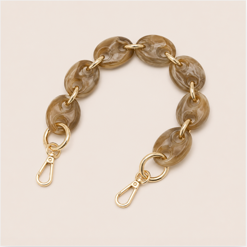 Folie à Trois Wilder short phone chain in coffee brown marbled puffed links with gold connectors, laid flat on a cream background.