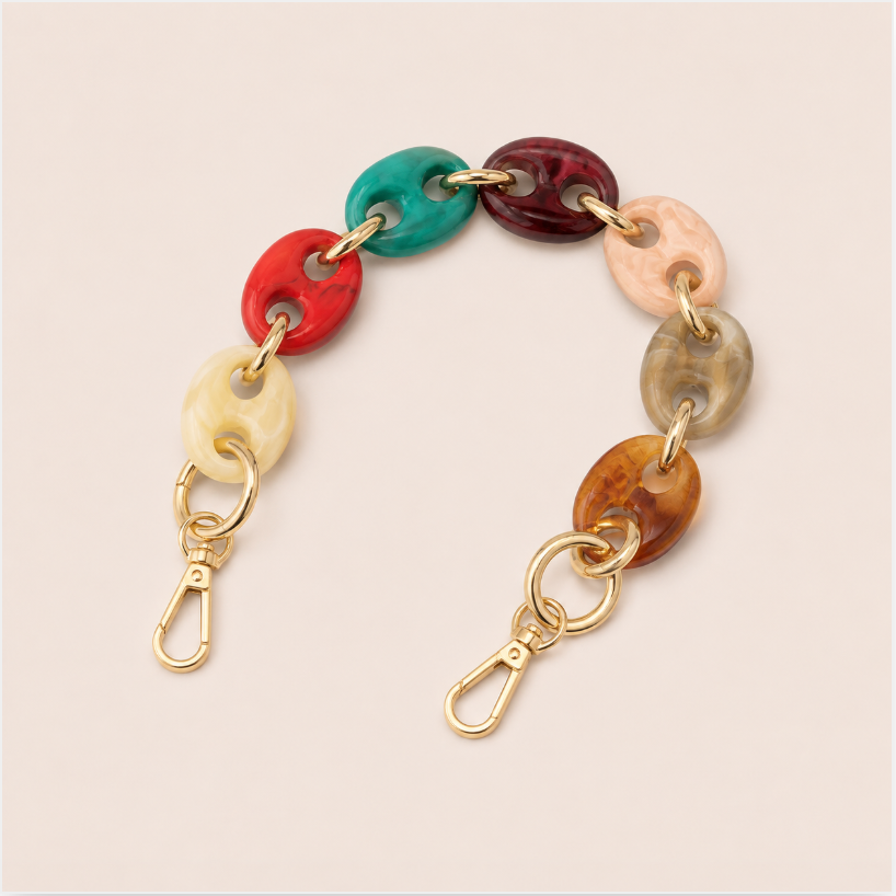 Folie à Trois Wilder short phone chain in multicolor puffed links with gold connectors, laid flat on a cream background.