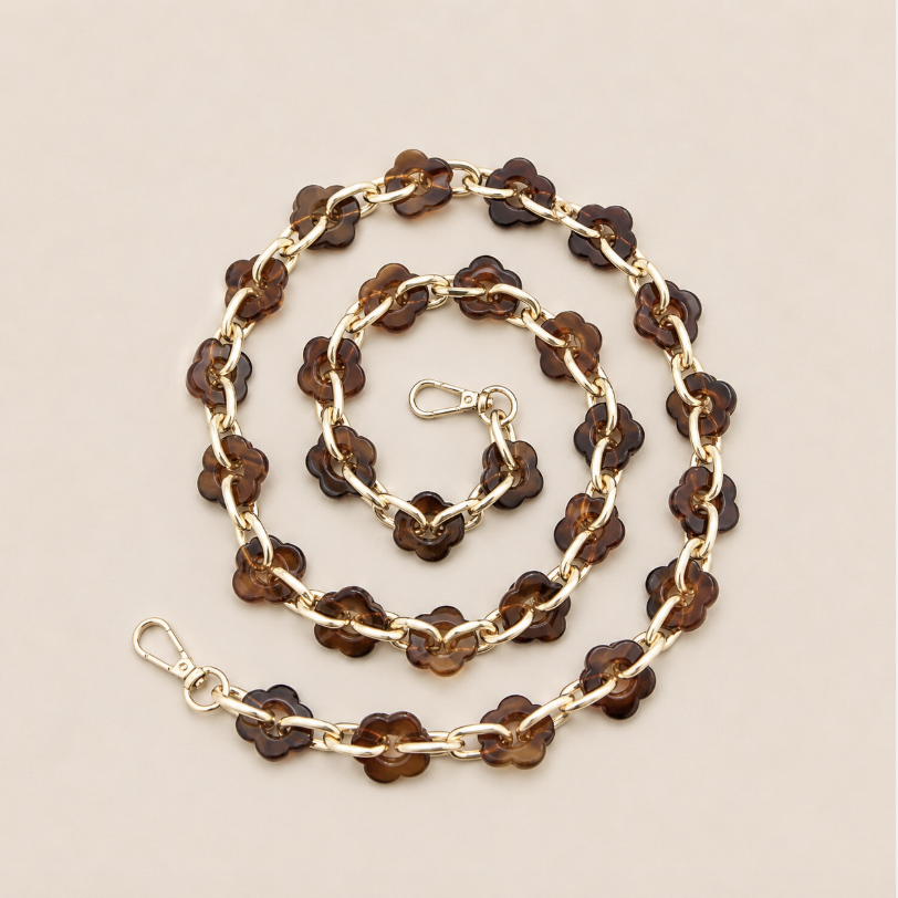 Coiled flower-link phone chain in amber tortoiseshell acrylic with gold chain links on cream — Folie à Trois Zinnia long phone chain