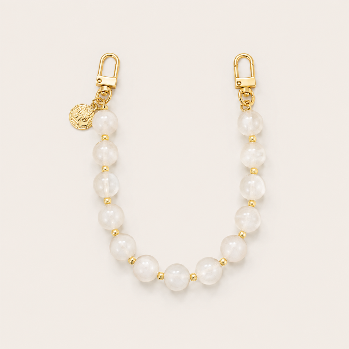 The Sable PHONE CHAIN in creamy white marbled beads with gold-tone spacer beads, clasps, and a small coin charm.