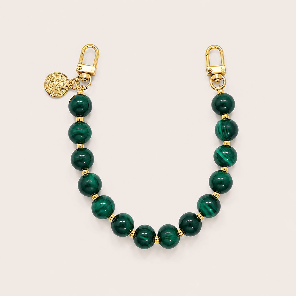 The Sable PHONE CHAIN in deep green malachite-effect beads with gold-tone spacers, clasps, and a coin charm.