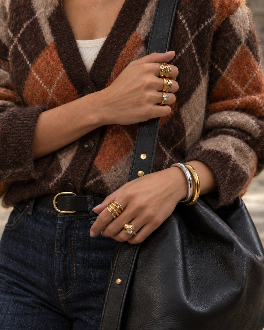 Woman in an argyle cardigan with gold rings and gold and silver-tone Arco BRACELETS stacked on her wrist — Folie à Trois
