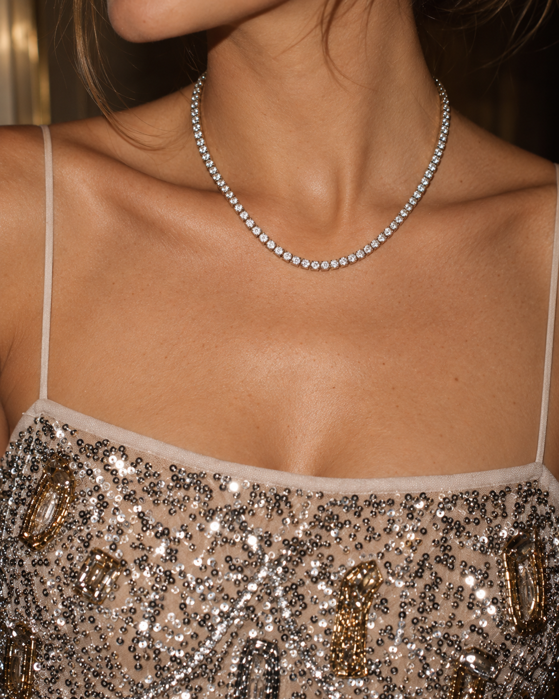 Silver-tone Rivière NECKLACE, a tennis necklace of round clear stones, worn with a sequinned champagne top.