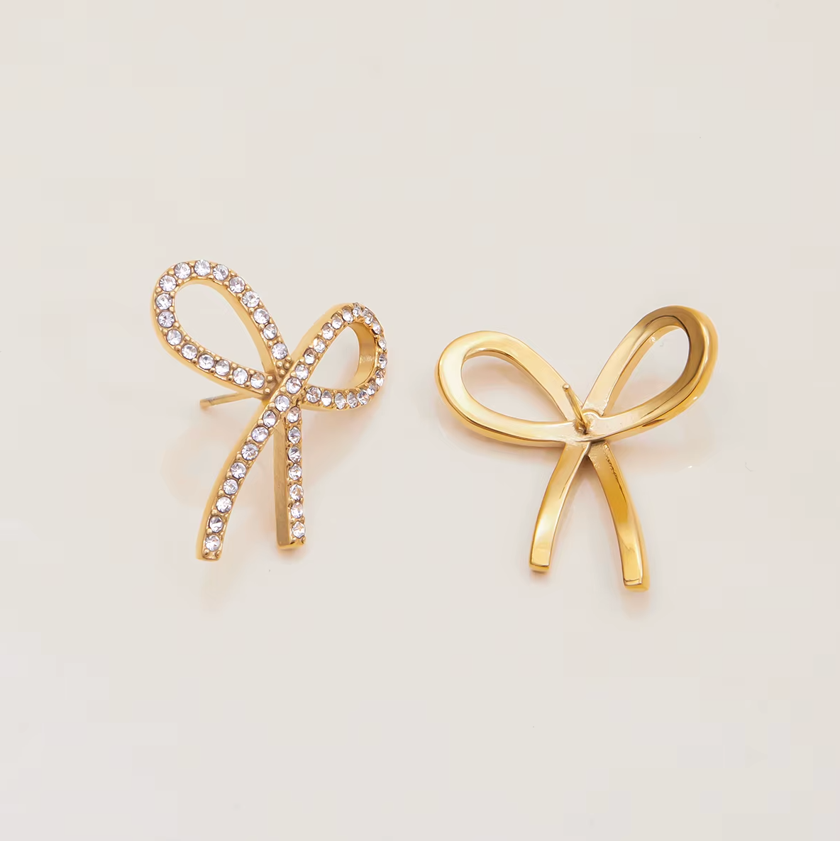 Gold-plated bow-shaped stud earrings embellished with clear crystal stones