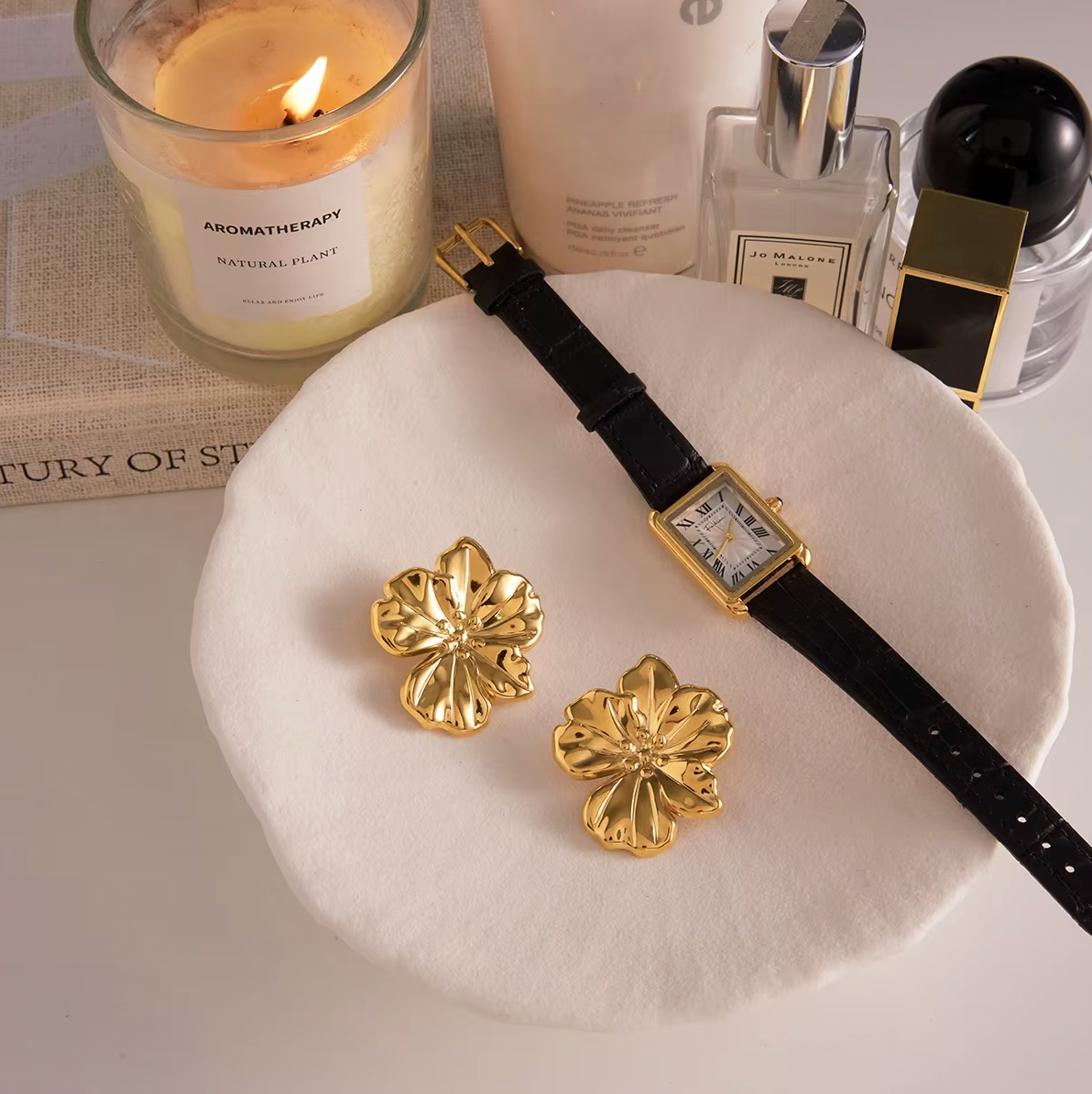 Gold-plated flower-shaped stud earrings with sculpted petals and a polished finish