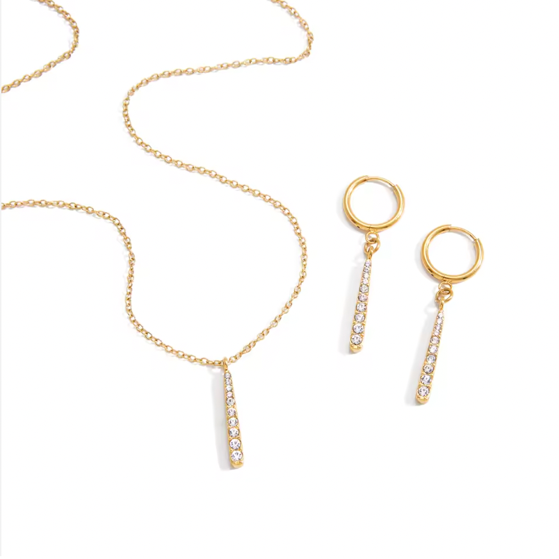 Gold-plated necklace with a fine chain and a slim vertical bar pendant set with clear crystal stones