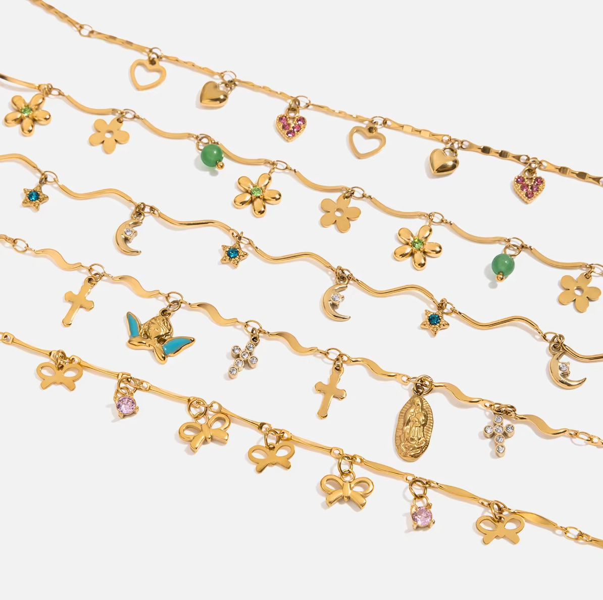 Gold-plated charm bracelet with multiple heart-shaped charms, including open hearts, polished gold hearts, and a pink crystal heart