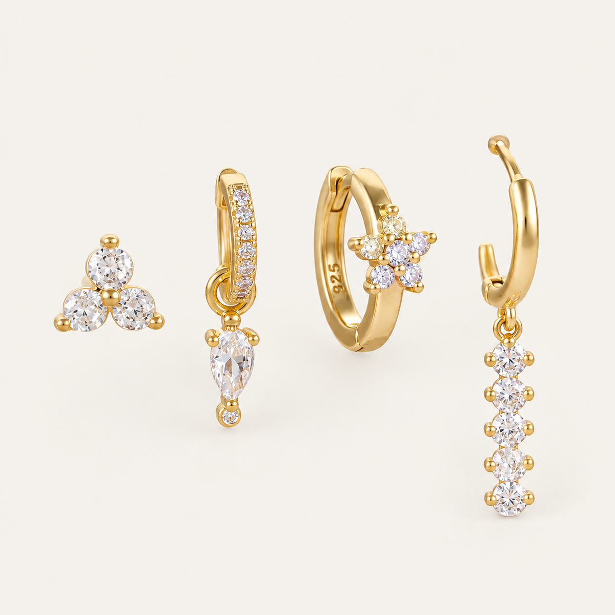 Four gold Folie à Trois Adele SET earrings: a trio stud, a pavé huggie with crystal drop, a flower hoop and a beaded dangle hoop.