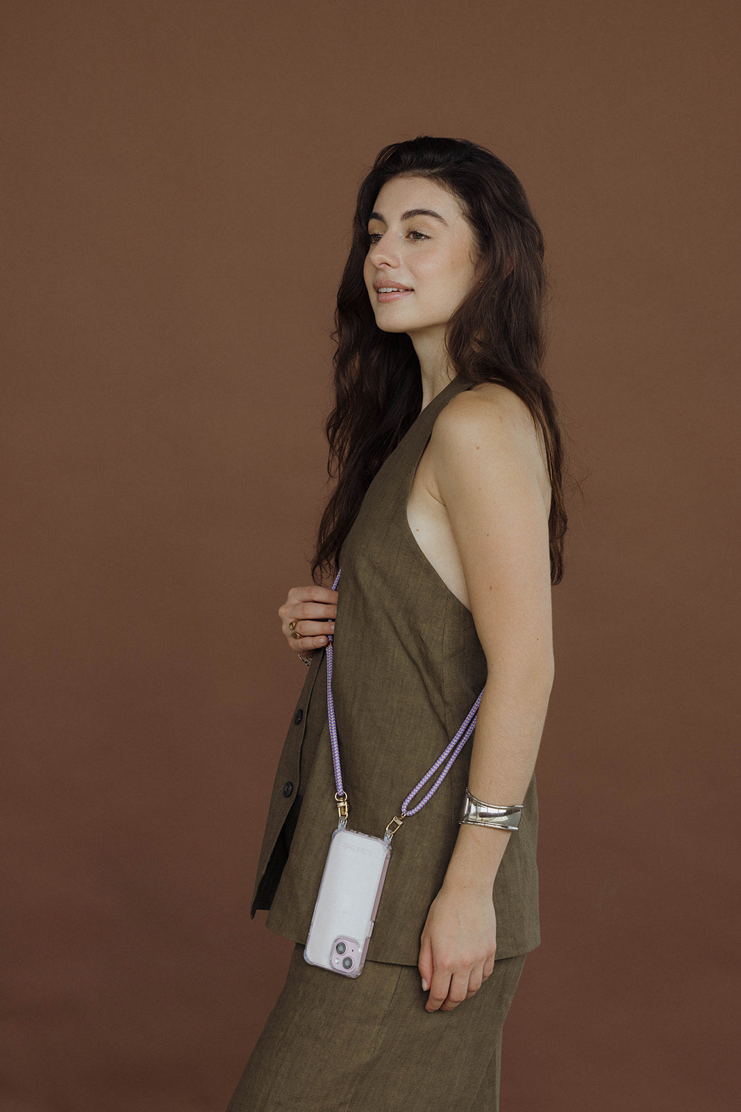 Woman in an olive outfit wearing a lavender Aesthetic Colorful PHONE CORD crossbody with a white phone case.