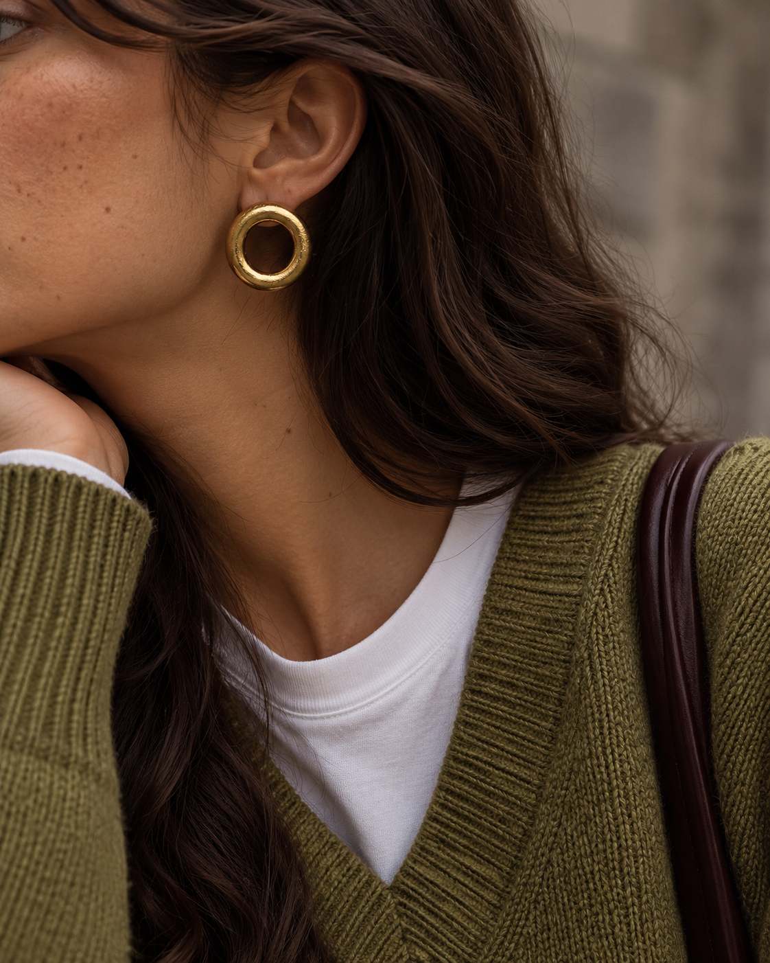 Bold gold Anello EARRINGS, a chunky rounded ring, worn with an olive V-neck knit over a white tee — Folie à Trois