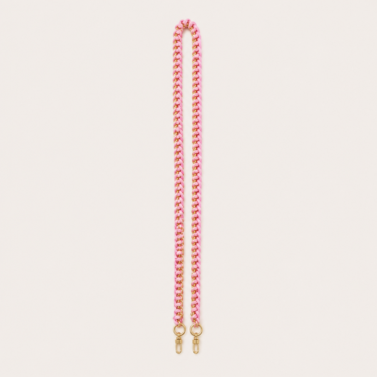 Folie à Trois Aspen long wholesale phone strap in pink and gold woven curb chain with gold clasps, laid straight on a cream background.