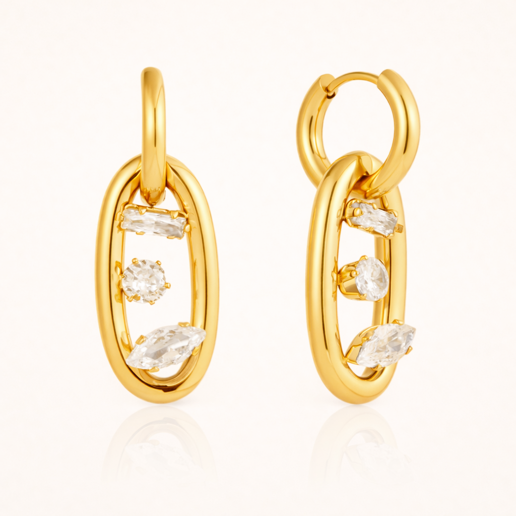 The Astral EARRINGS pair an open gold hoop with an oval link set with baguette, round, and marquise crystals.