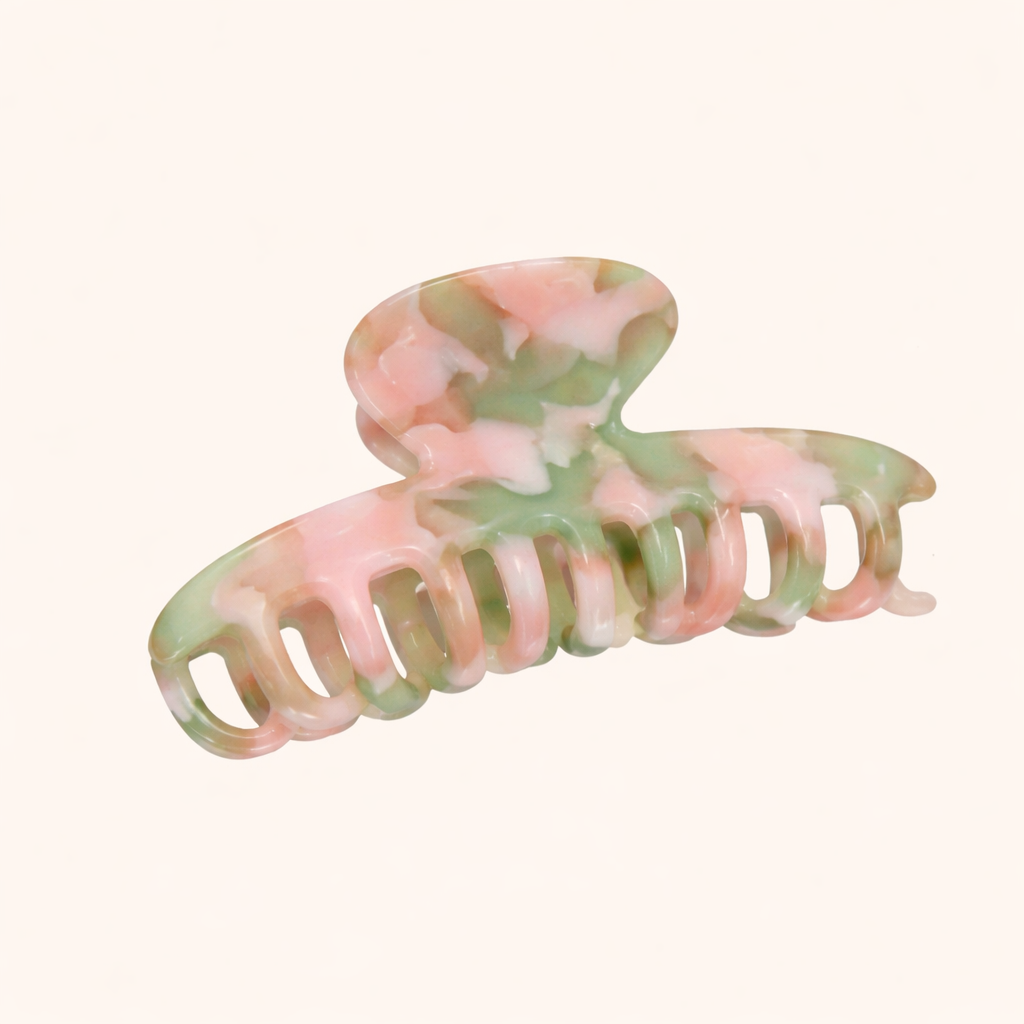 Pink and green pastel marbled acetate claw clip from the Baby Love HAIR CLIP collection, shown on a cream studio background.