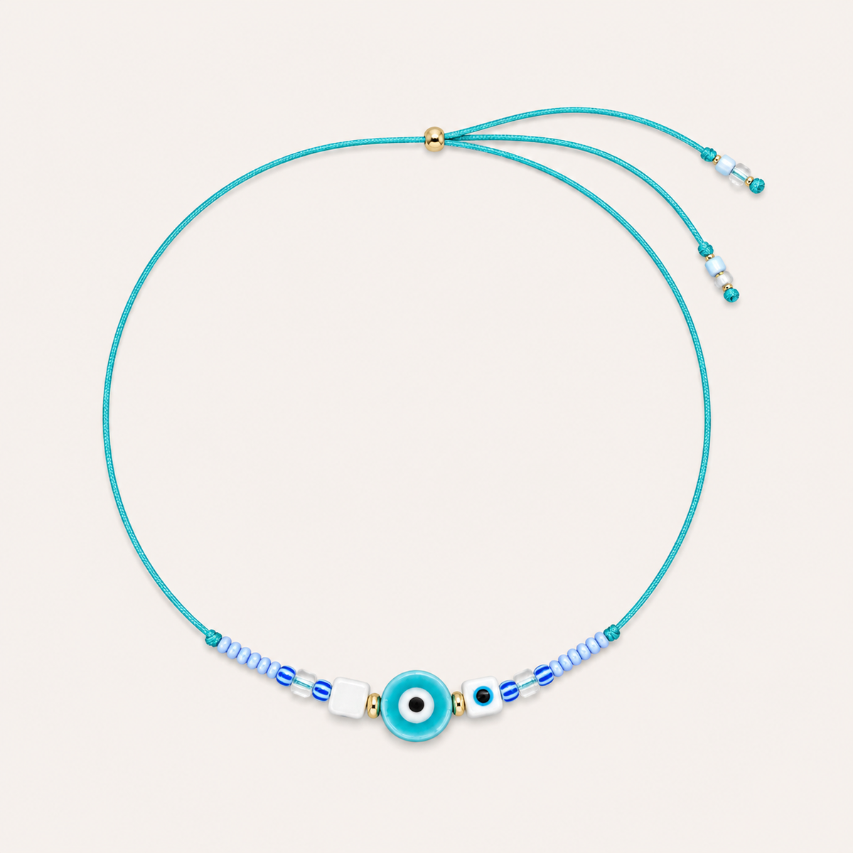 Teal cord Big Eye NECKLACE with beaded blue and white accents around a teal enamel evil eye charm, laid flat.