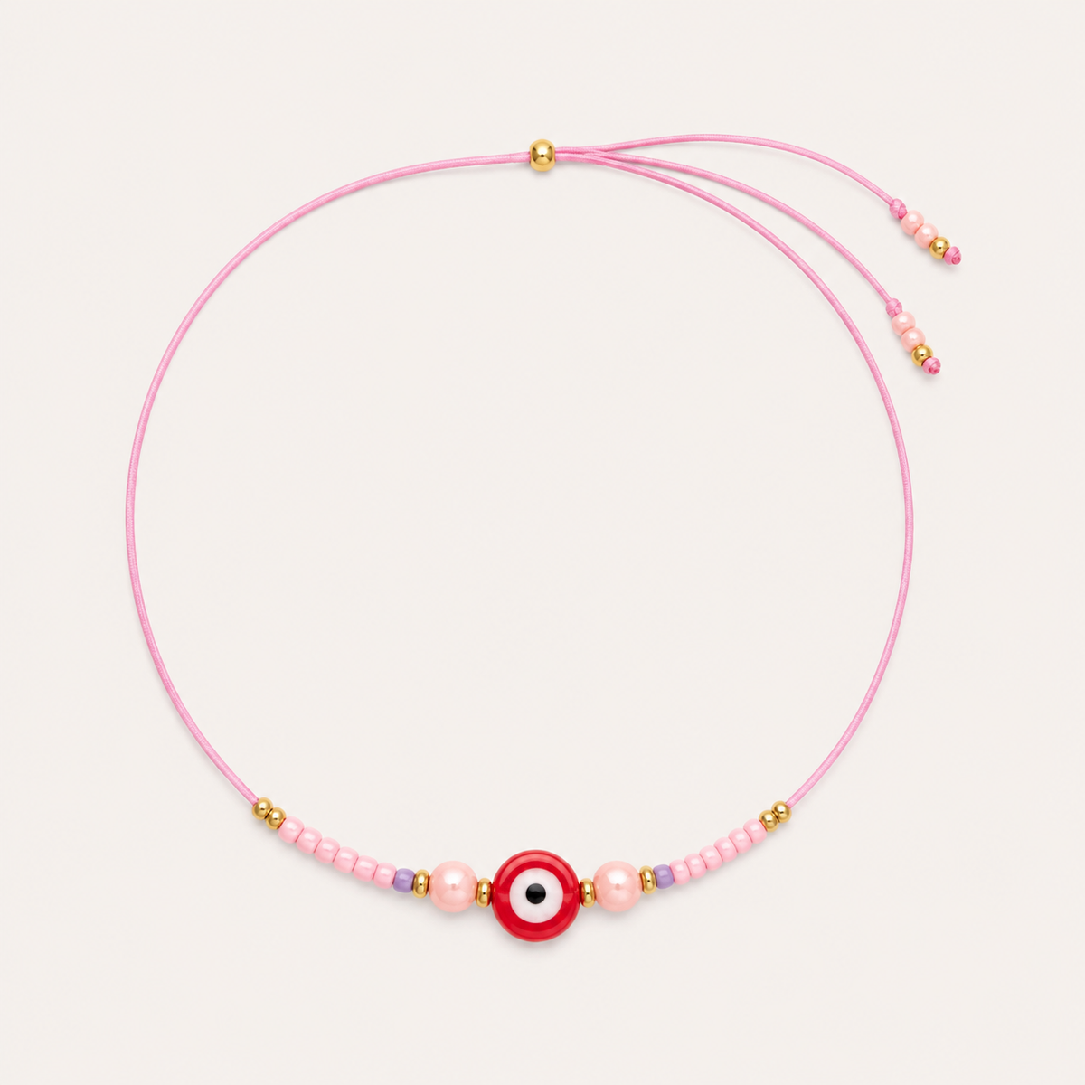 Pink cord Big Eye NECKLACE with beaded pearl and lilac accents around a red enamel evil eye charm, laid flat.