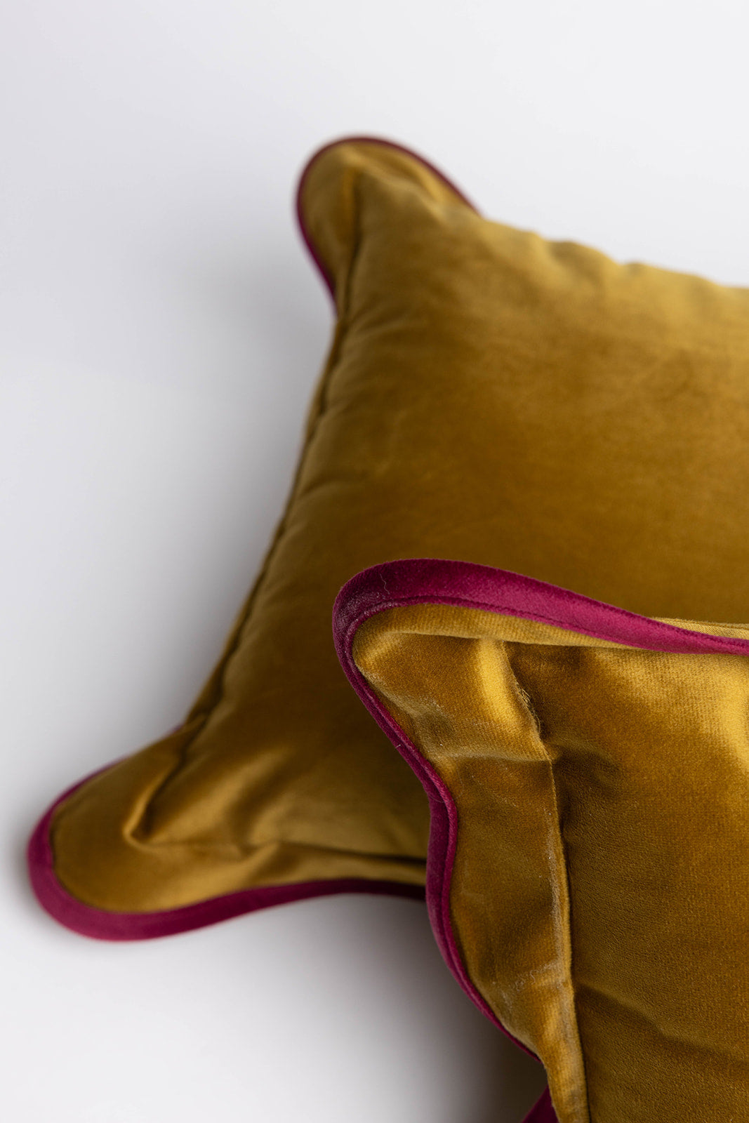Two overlapping olive-brown velvet cushions with cream scalloped edges, flat lay from the Billie Rectangle Velvet cushion range.