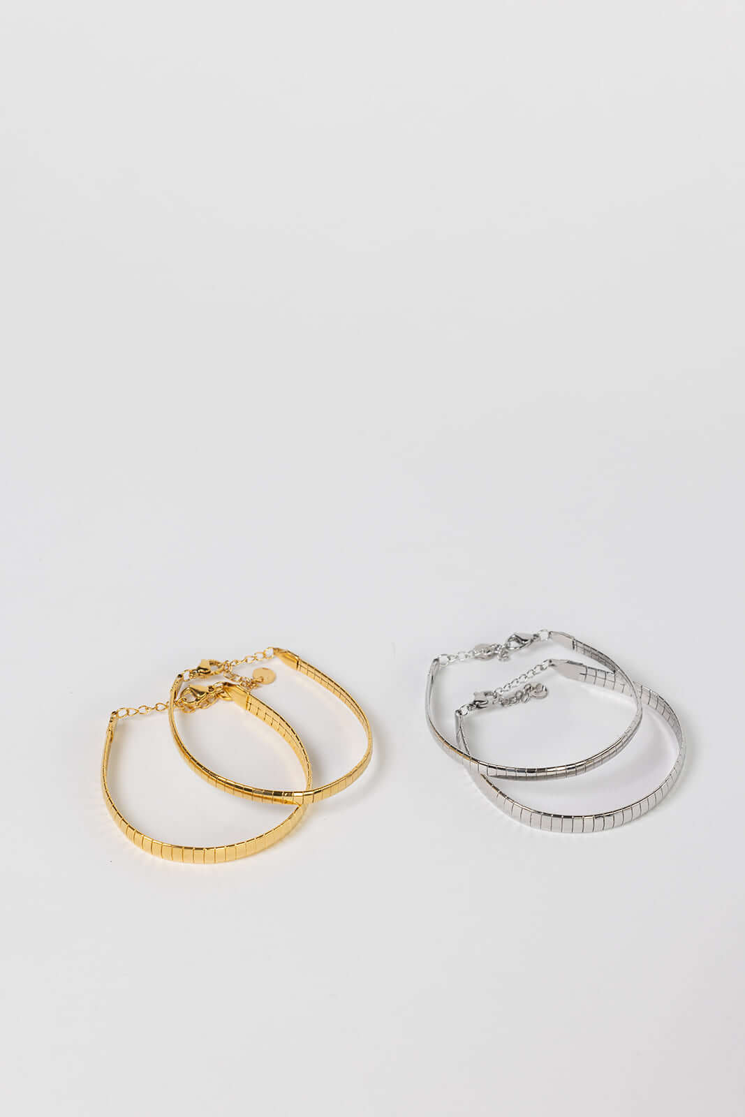 Braided Babe BRACELET in gold and silver, two pairs of slim twisted-texture bangles laid side by side on a white background.