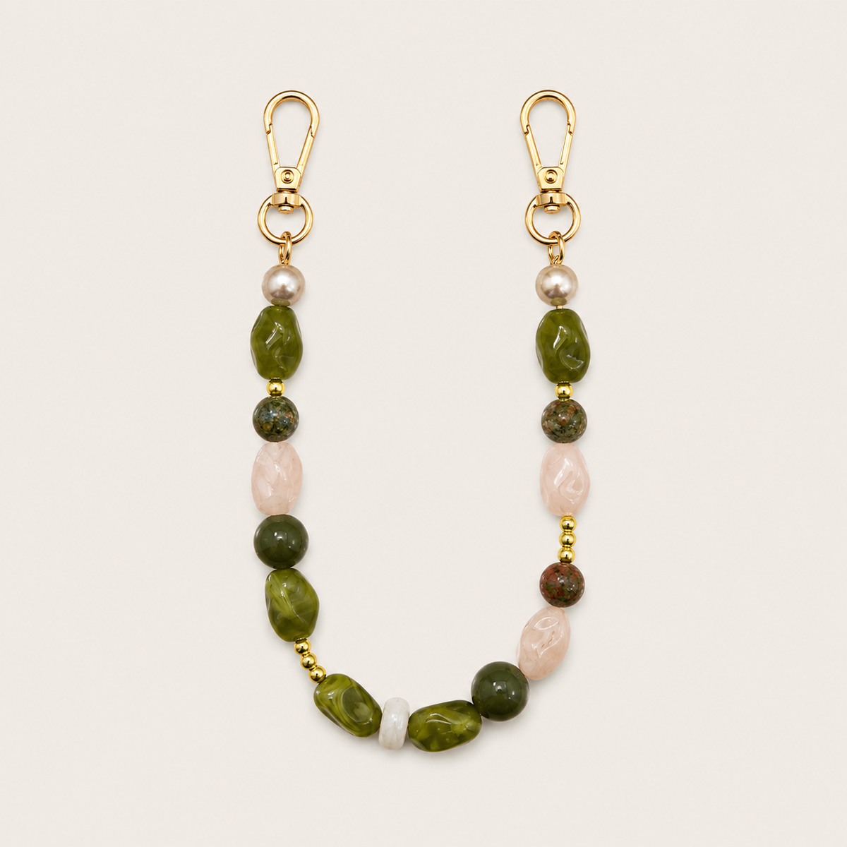 Folie à Trois Briar short wholesale phone chain in mixed green, blush and pearl gemstone nugget beads with gold spacers and gold clasps, on a cream background.