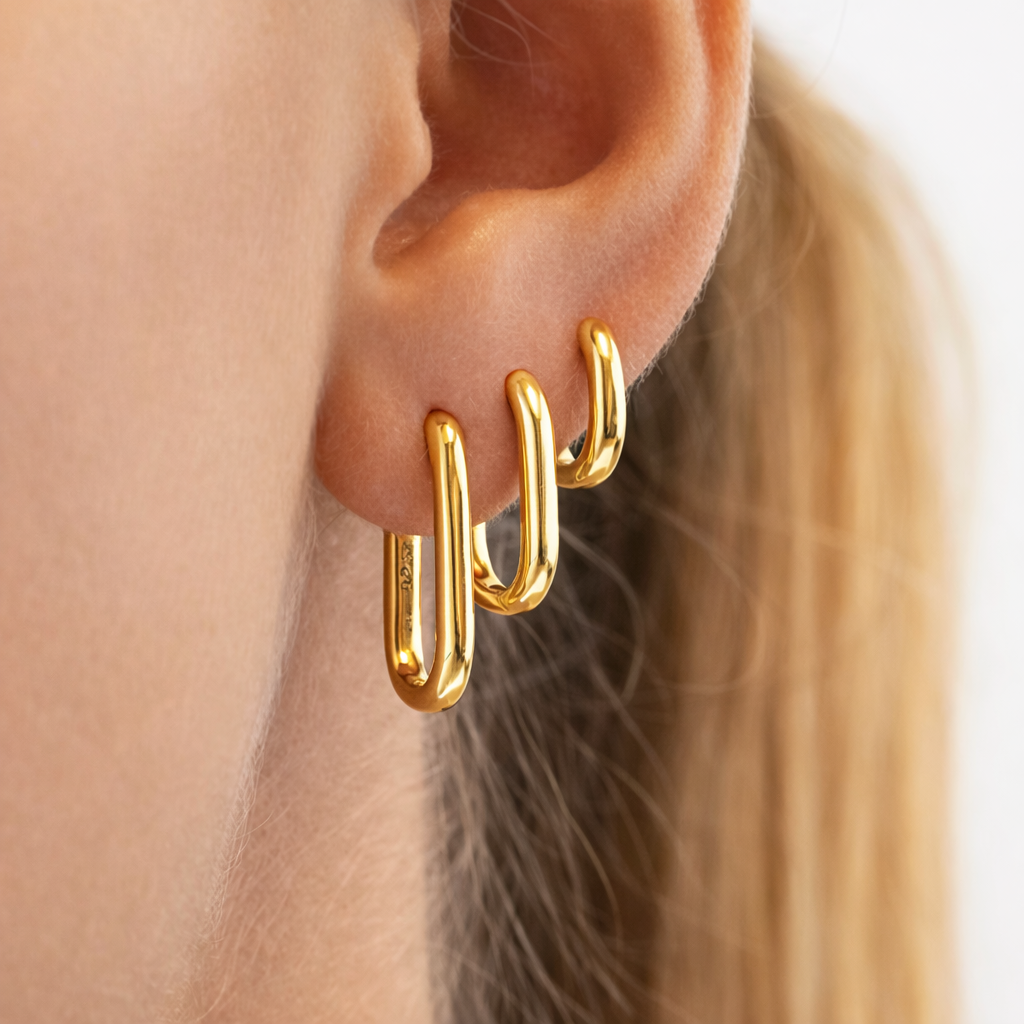 Bruna Set worn on the ear in gold, three rectangular oval hoops stacked from smallest to largest size.