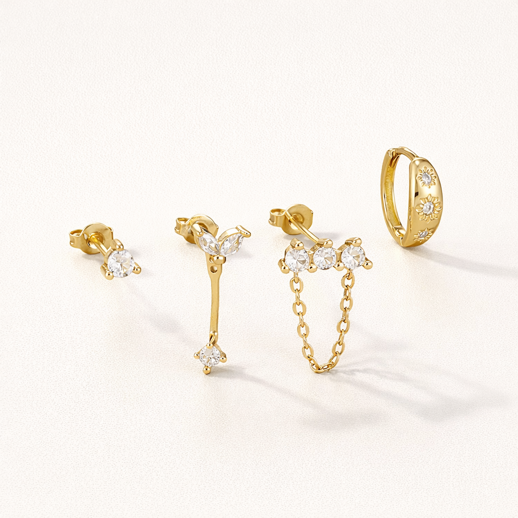 Capucine Set of gold jewelry, a crystal stud, a marquise leaf drop, a chain stud, and a star-set pave hoop.