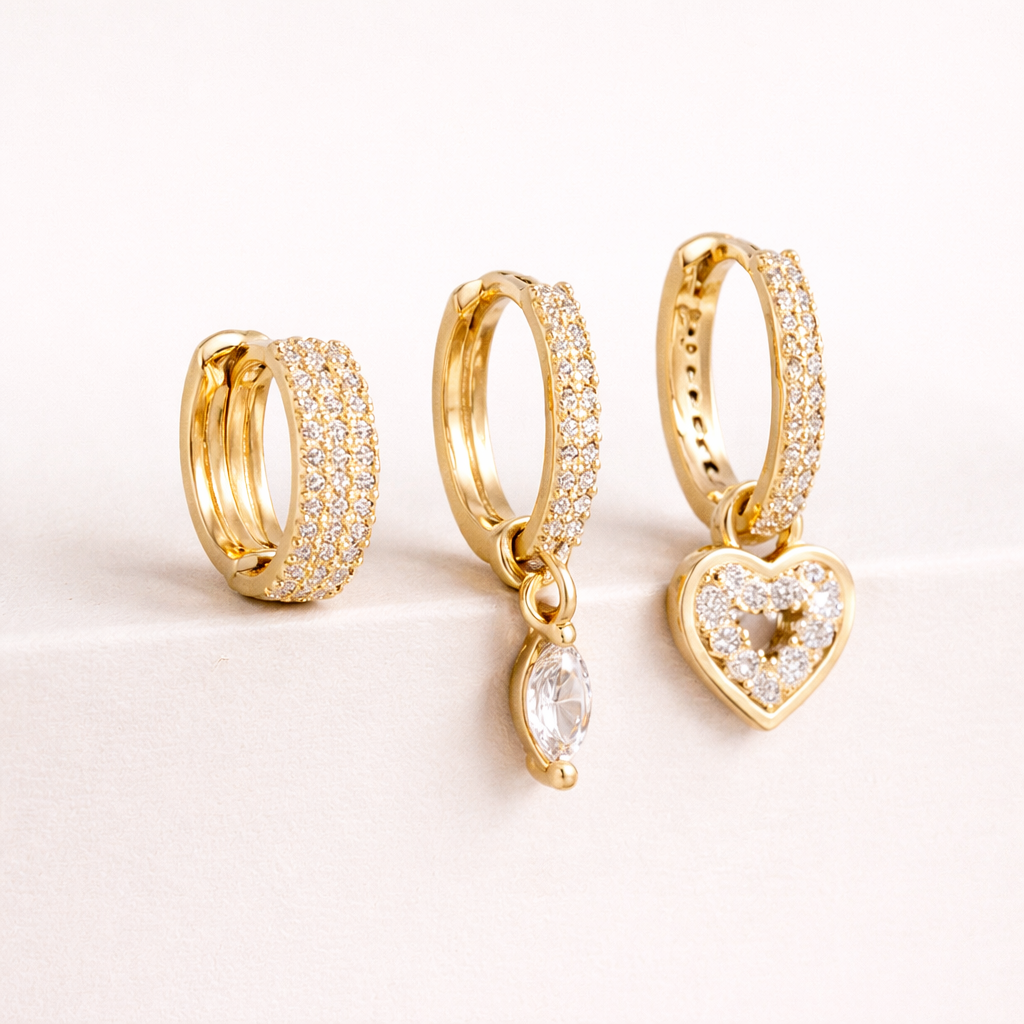 The Cara SET includes three gold huggie hoops, one pave-lined, with a marquise crystal drop and a pave heart charm.