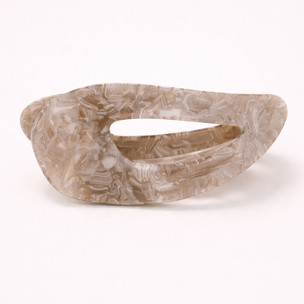 Clara HAIR CLIP wave-shaped acetate barrette in a beige and brown marbled pattern, studio shot.