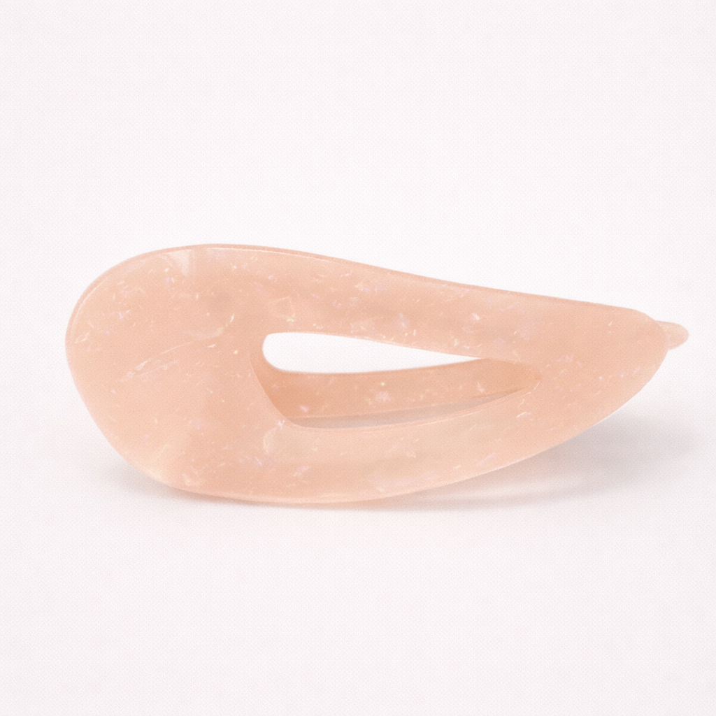 Clara HAIR CLIP wave-shaped acetate barrette in a soft peach-pink shade, studio shot.