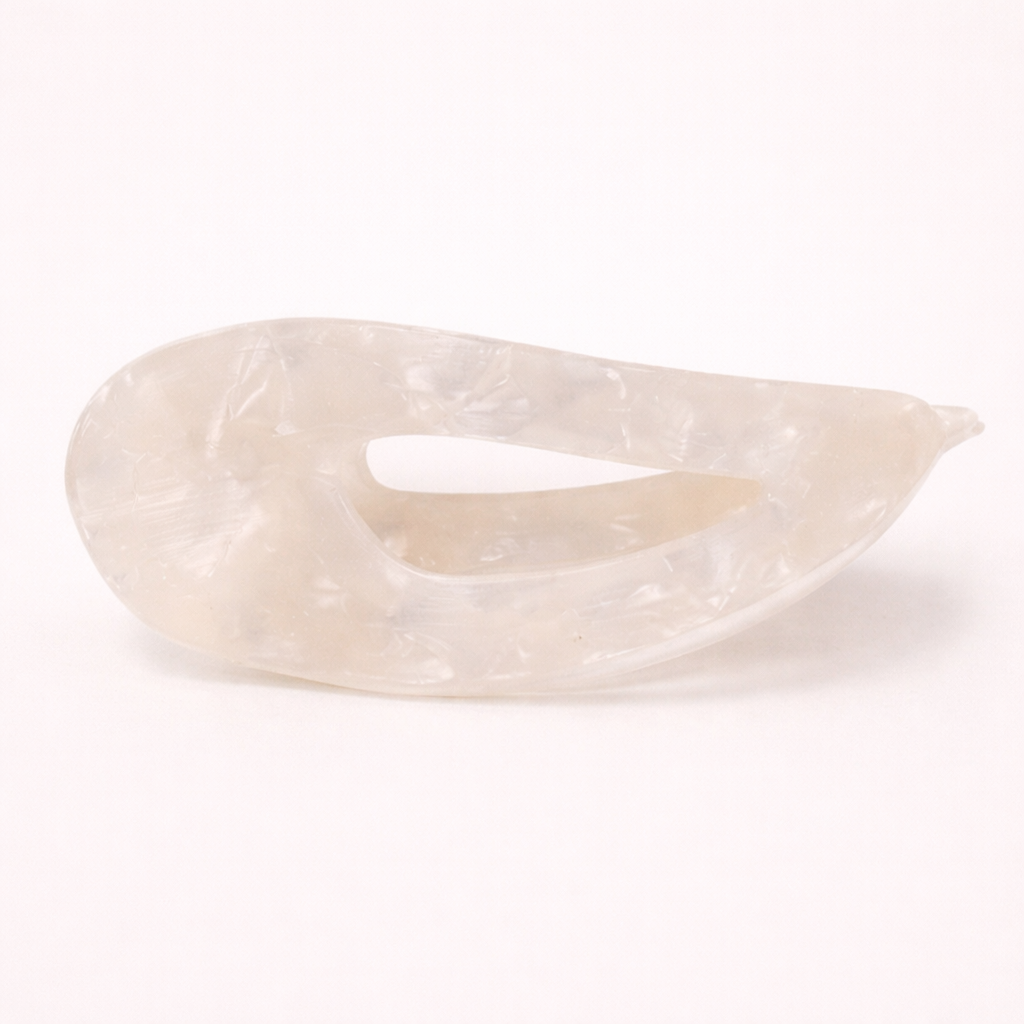 Clara HAIR CLIP wave-shaped acetate barrette in a pearly white and cream marbled pattern, studio shot.