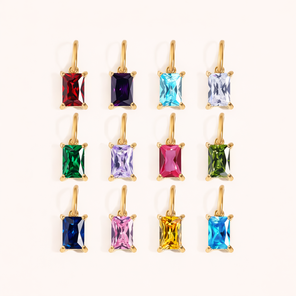 Twelve Classic Drop Charm pendants in a grid, each a rectangular gemstone in a gold prong setting, spanning red, blue, green and pink hues.