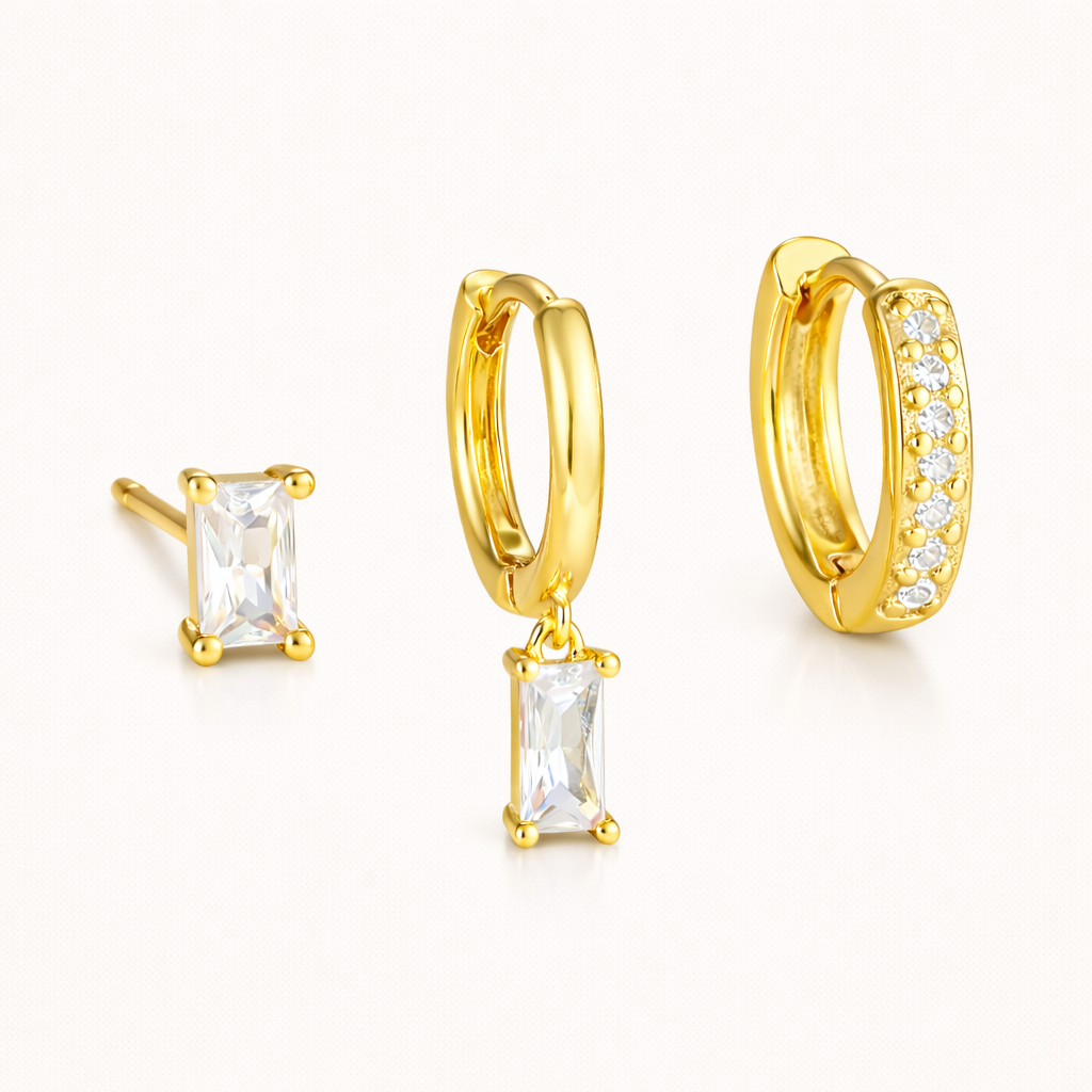 The Classic Drop SET in gold with a clear crystal baguette stud, matching dangle hoop, and pavé huggie hoop, shown together in studio.