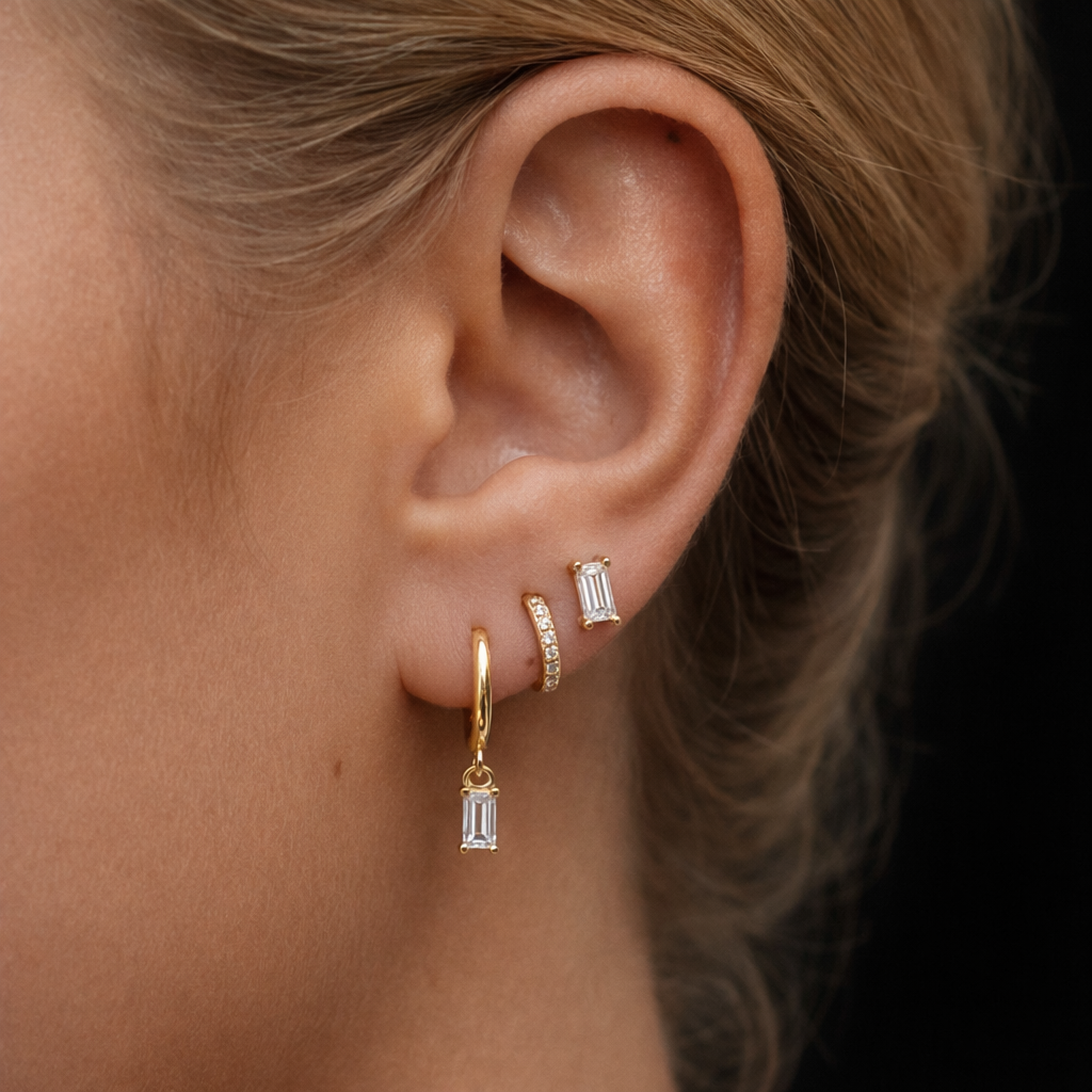 A model wears the Classic Drop SET in clear crystal, pairing a baguette stud, dangle hoop, and pavé hoop along the ear.