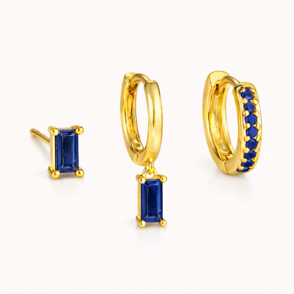 The Classic Drop SET in a sapphire blue colorway, featuring the baguette stud, dangle hoop, and pavé hoop in a studio shot.