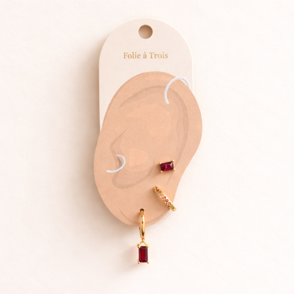 The Classic Drop SET in a garnet red colorway displayed on a branded Folie à Trois ear card with the stud, pavé hoop, and dangle hoop.