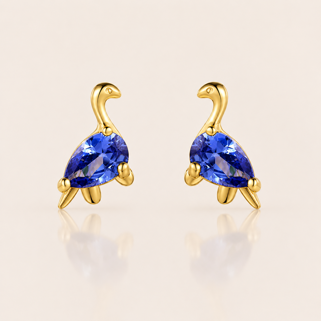 Gold long-necked dinosaur stud earrings from the Colorful Dino EARRINGS with a blue pear-cut cubic zirconia body and curved upright neck.