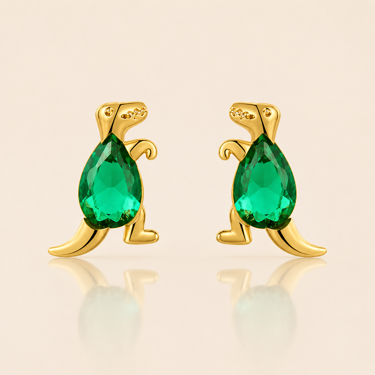 Gold T-Rex-shaped stud earrings from the Colorful Dino EARRINGS with a green pear-cut cubic zirconia body standing upright on two legs.
