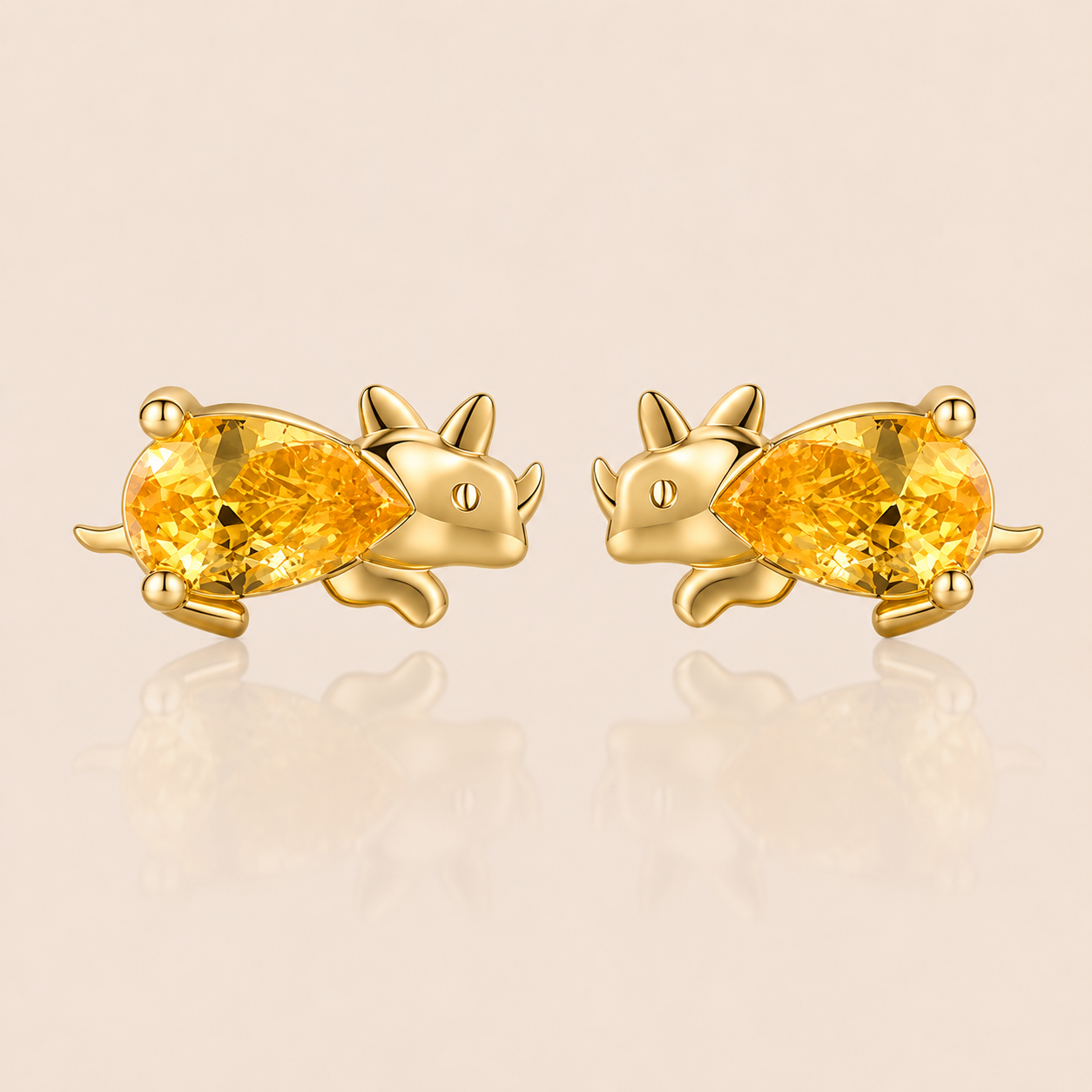 Gold triceratops-shaped stud earrings from the Colorful Dino EARRINGS with a yellow pear-cut cubic zirconia body and horned head.