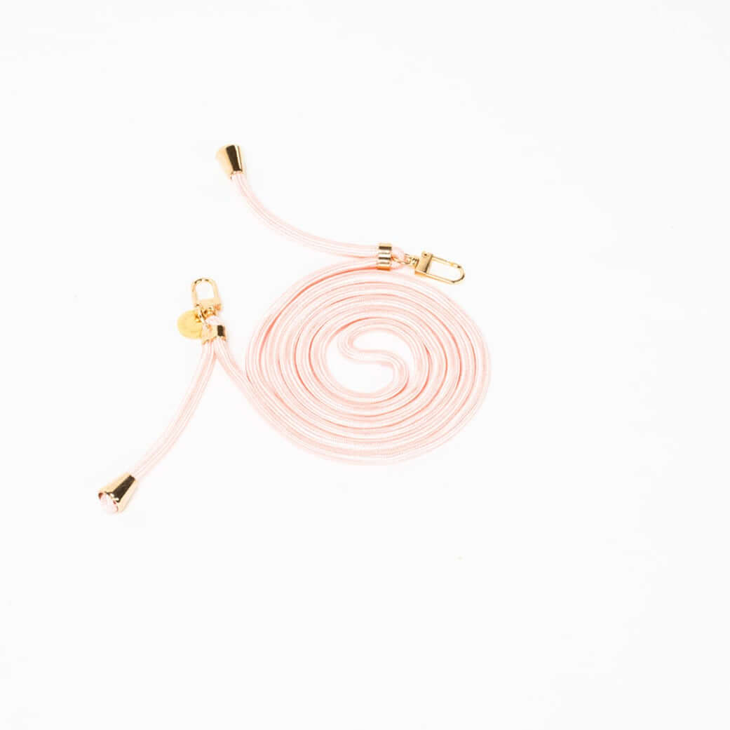 Pale pink Colorful PHONE CORD coiled with gold-tone hardware on a white background.