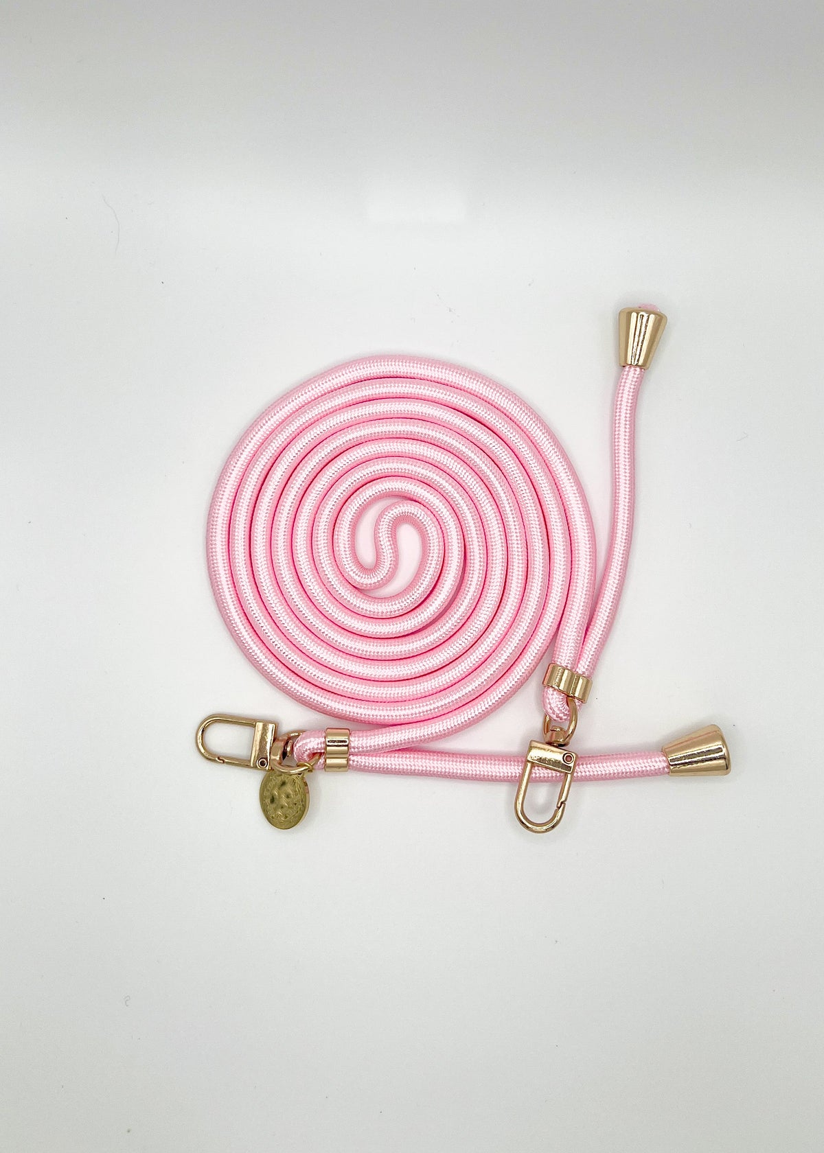 Pink and white Colorful PHONE CORD coiled with gold-tone hardware on a white background.