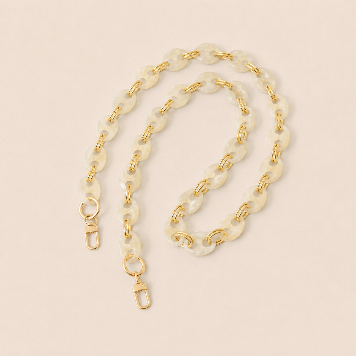Ivory marbled coin-link phone chain with gold connectors coiled on cream — Folie à Trois Corvin long phone chain