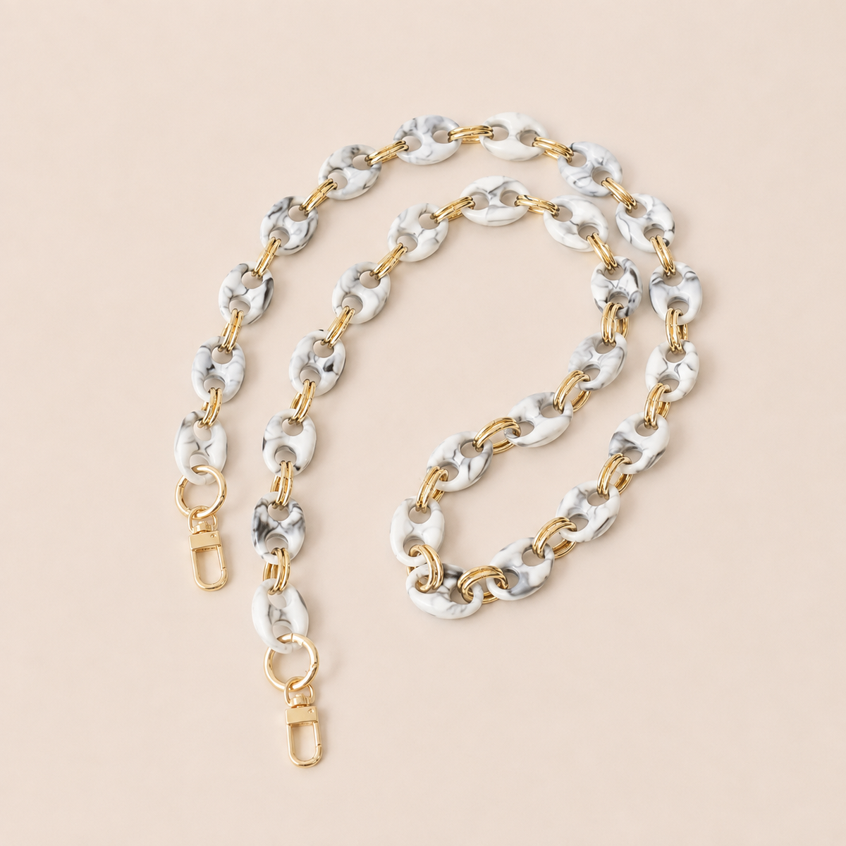 White and black marbled coin-link phone chain with gold connectors coiled on cream — Folie à Trois Corvin long phone chain