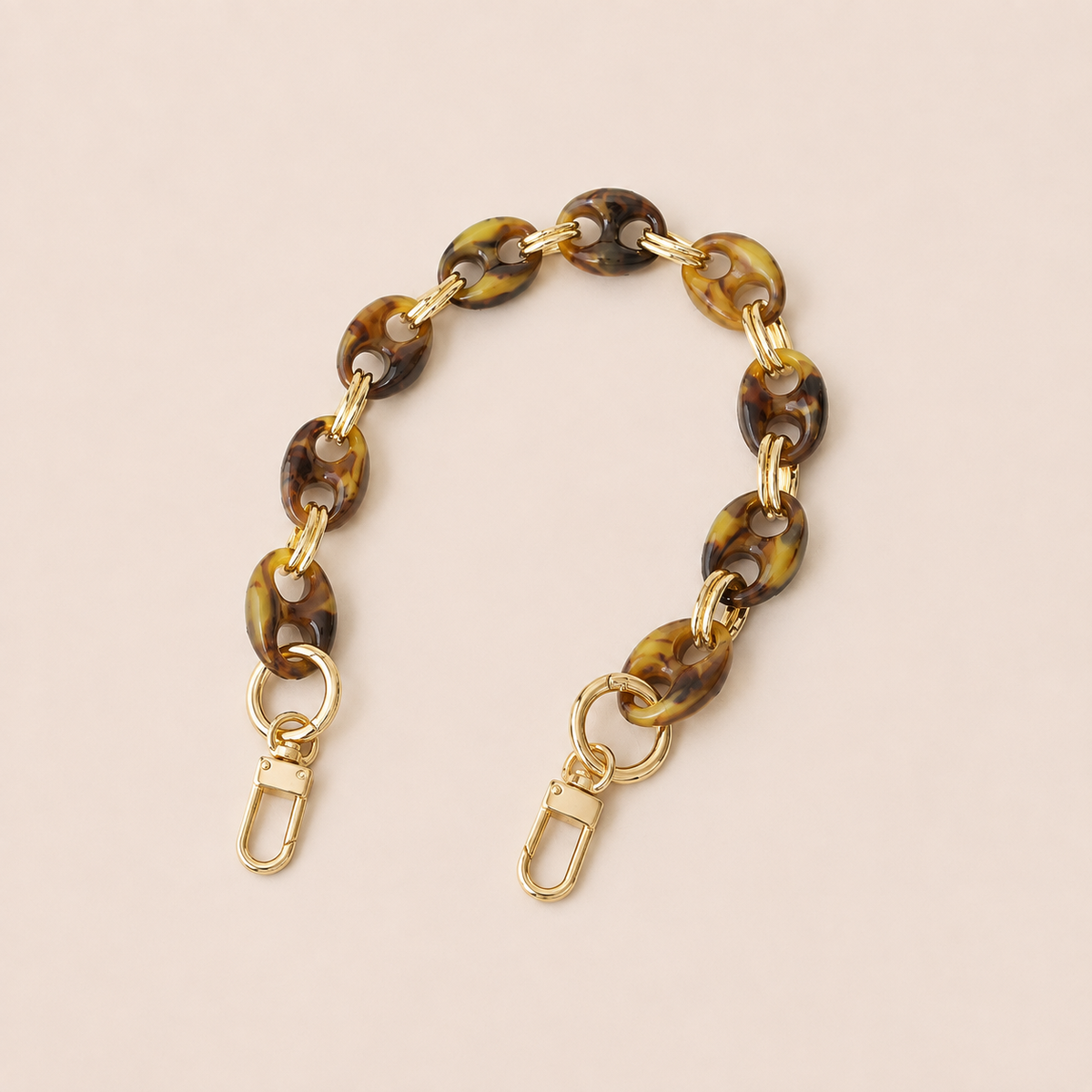 Round olive brown tortoiseshell coin-link phone chain with gold connectors on cream — Folie à Trois Corvin short phone chain