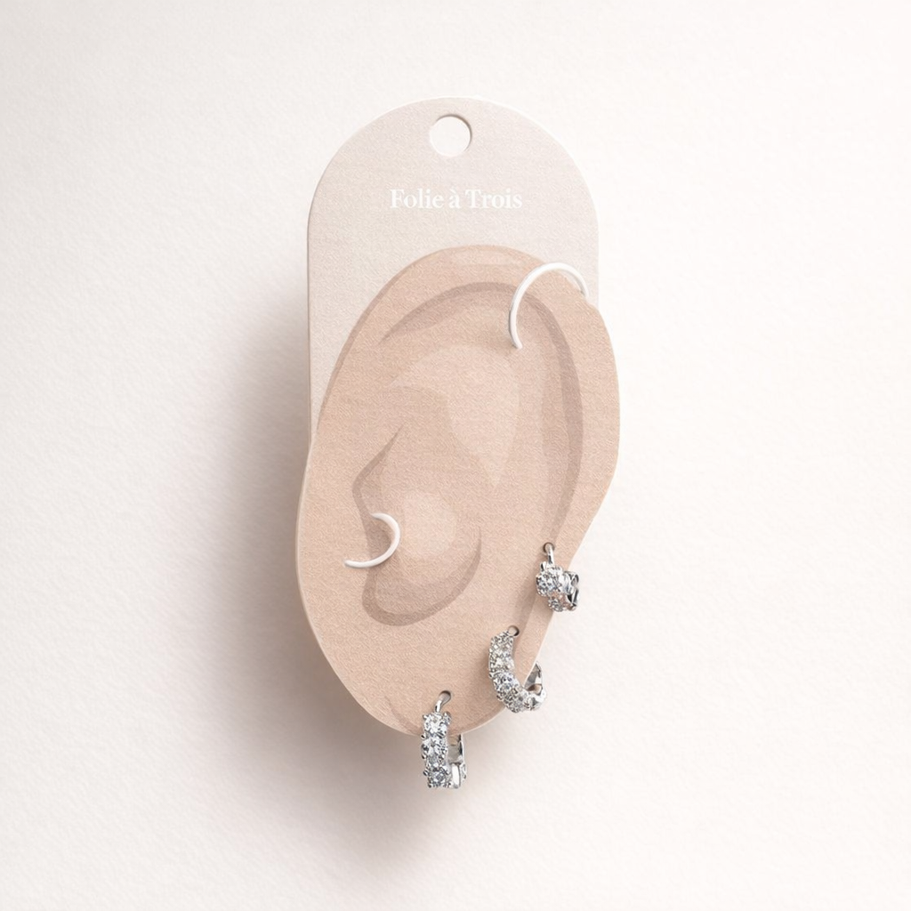 Illustrated Folie a Trois earring card showing the silver-tone Daisy Set pieces on an ear-shaped display.