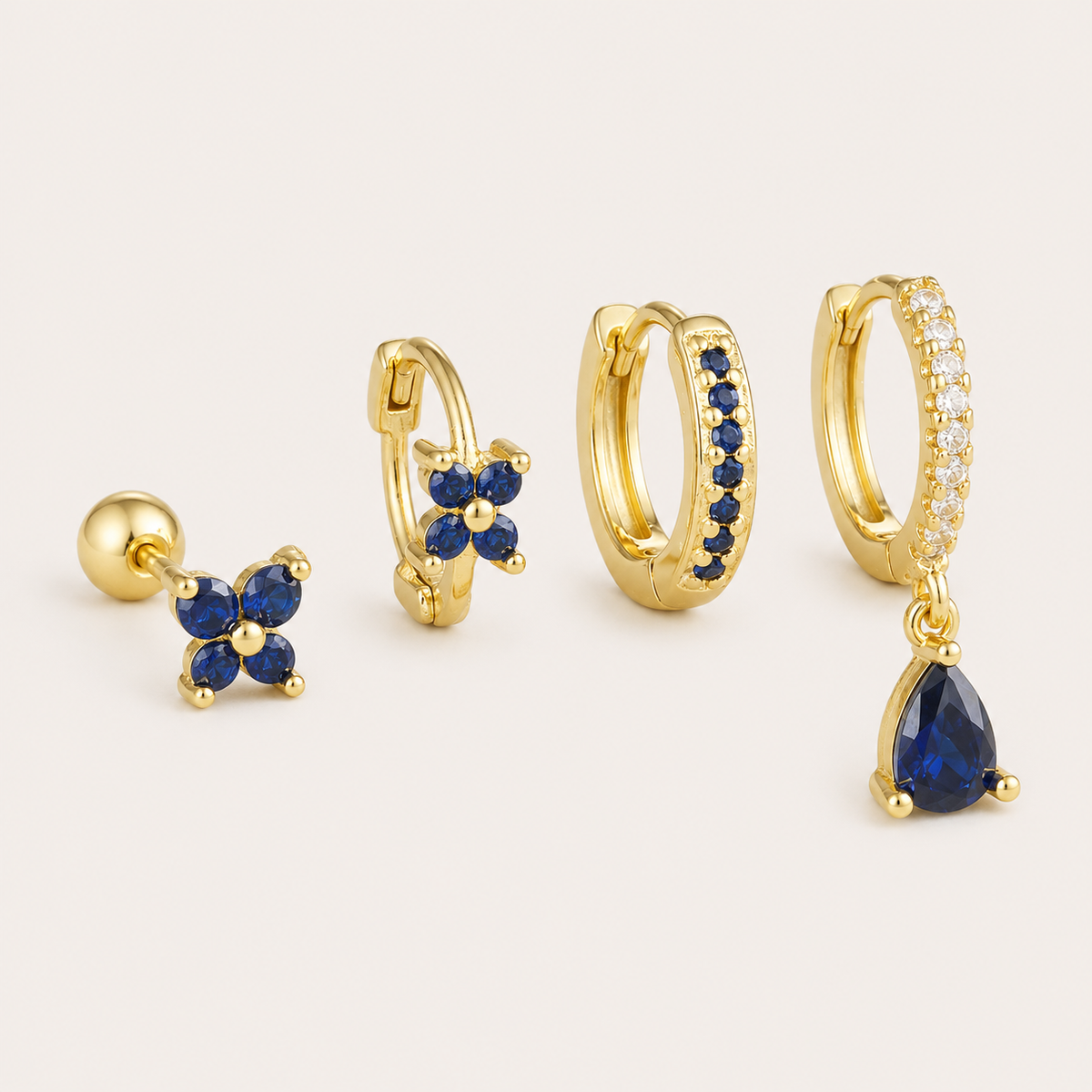 Four-piece Deanna SET gold earrings in blue: a flower stud, a flower hoop, a pave hoop, and a pave hoop with a pear-cut drop charm.