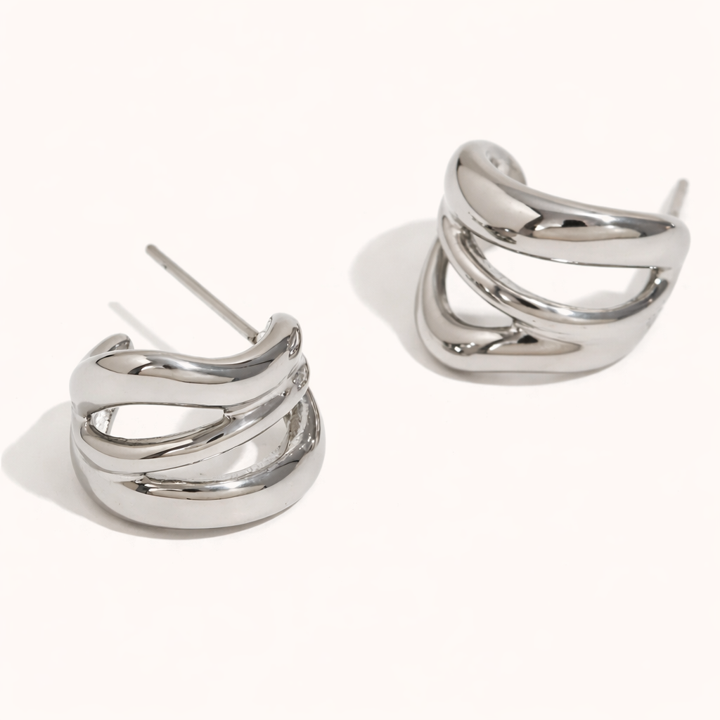 Delphi Earrings in polished silver, a chunky wide hoop formed by twisting interlaced bands for a sculptural finish.