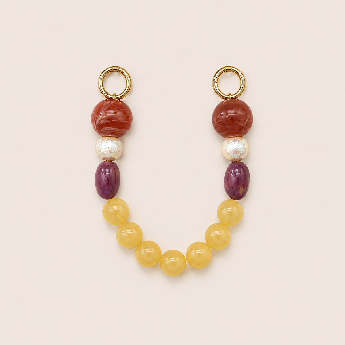 Red, pearl, purple, and yellow bead phone chain with gold hoop clasps laid flat on cream — Folie à Trois Delphine short phone chain