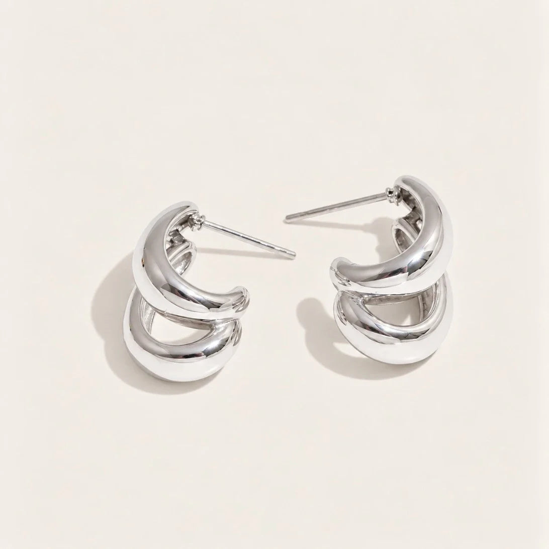 Silver-tone Doppia EARRINGS: a pair of hoops formed by two smooth C-shaped curves layered together — Folie à Trois