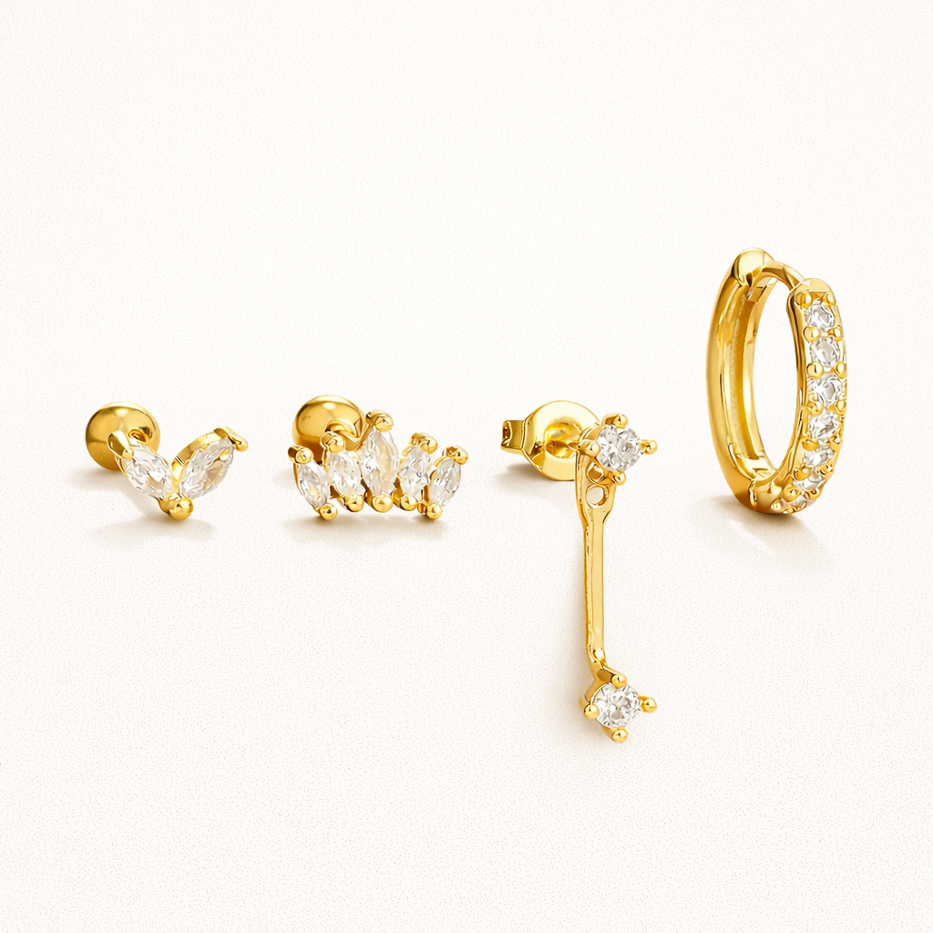 Elodie Set of four gold pieces: a marquise cluster stud, a wider marquise crown stud, a crystal drop stud, and a pave huggie hoop.