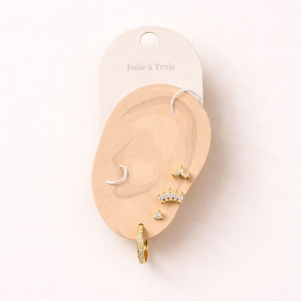 Elodie Set displayed on a Folie a Trois ear-shaped card, arranging the four gold studs and huggie hoop for easy styling.