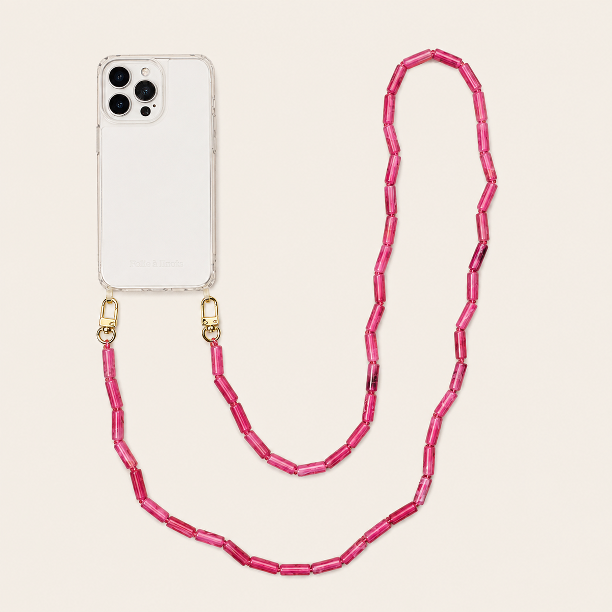 Pink tube-bead phone chain clipped to a clear iPhone case on a cream background — Folie à Trois Elowen wholesale phone chain