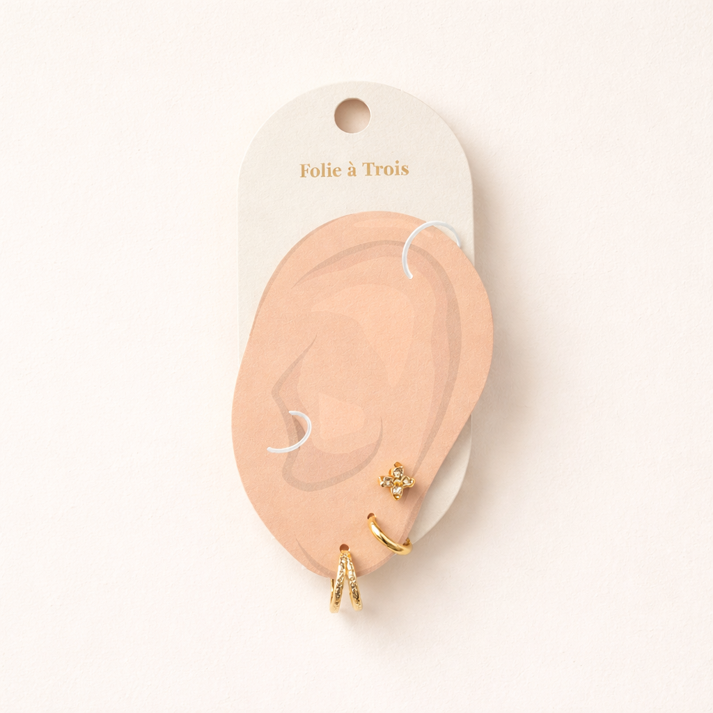 Illustrated Folie a Trois earring card showing the Faye Set pieces arranged on an ear-shaped display.